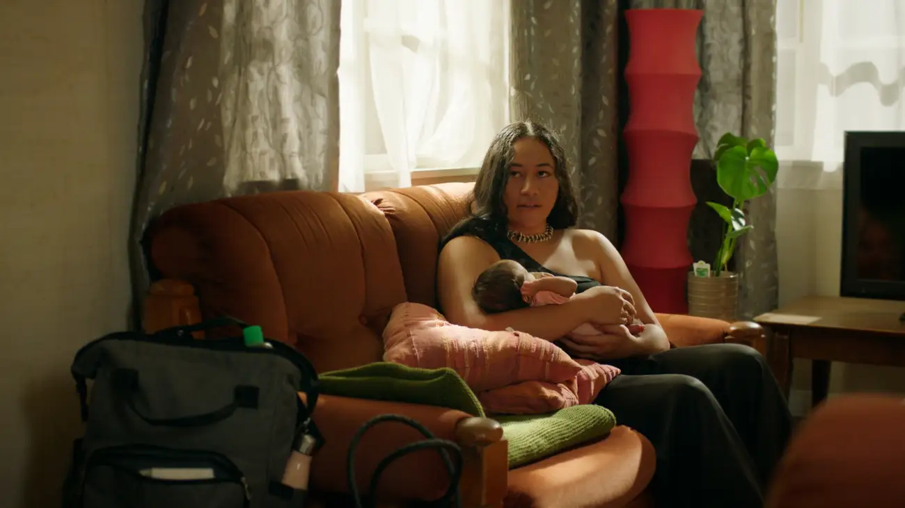 Alofa holds a tiny baby in the lounge of Te Pā.