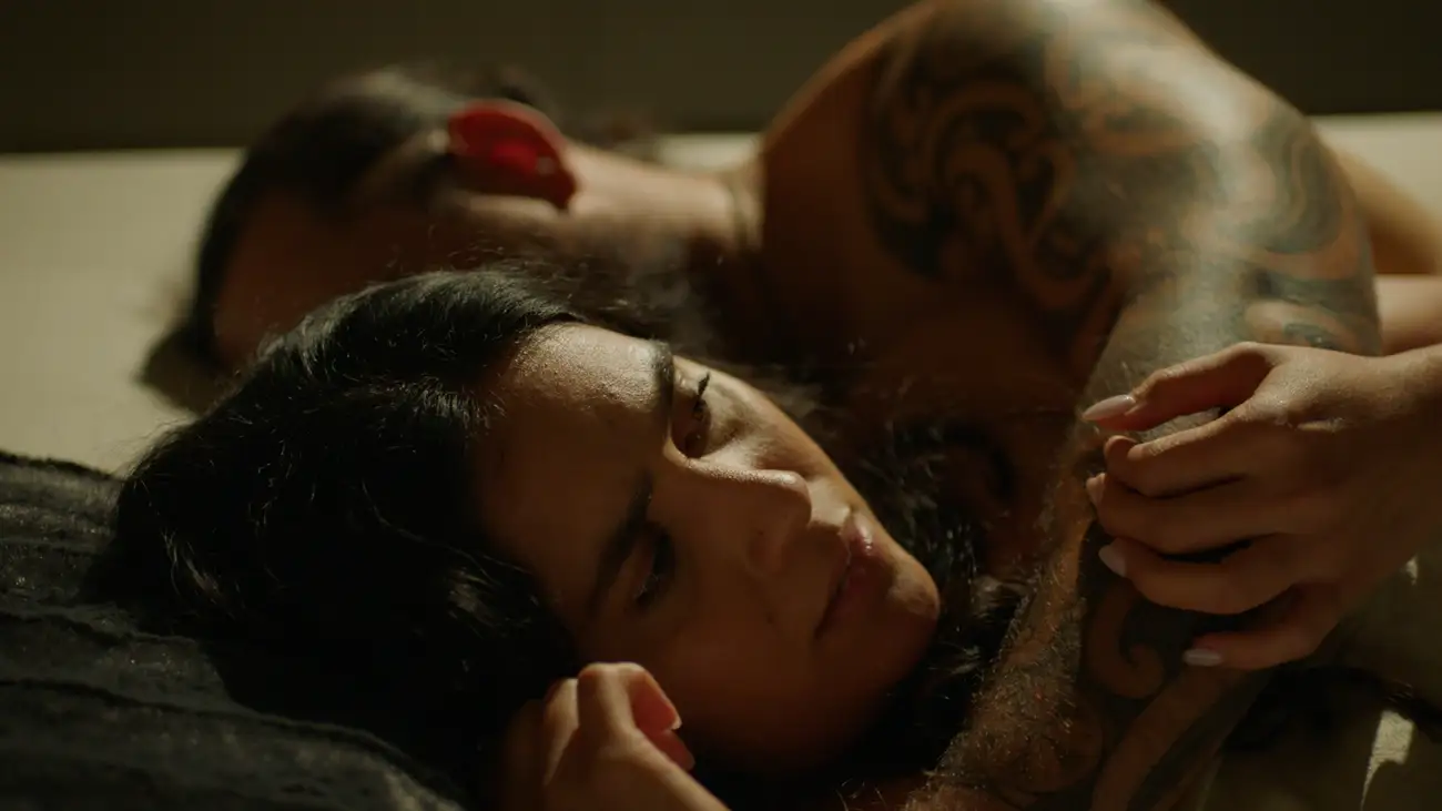 Marina looks worried with Hemi's arm around her in bed.