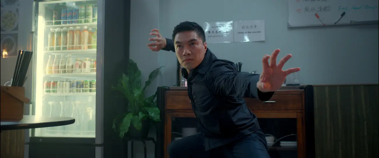 Winson holds a strong kung fu pose in a modern Chinese diner.