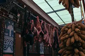Meat and blood sausages drying on a rack to preserve.