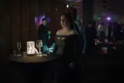 Mariana stands alone at a colourful party.
