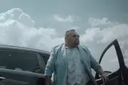 Comedian Tofiga Fepulea'i as Bob Titilo, steps out of a car, smartly dressed in a sky-blue suit.